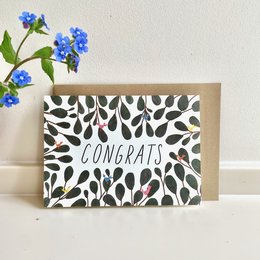 Congratulations card with a patterned design featuring black and white shapes. The card reads "CONGRATS" in white text.
