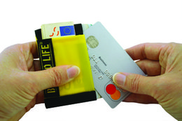 Compact travel wallet with card slots and zipper compartment, made of durable yellow material with black text.