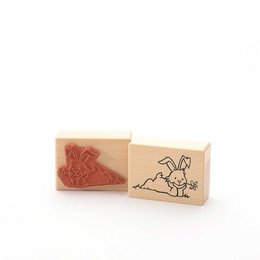 Rubber stamp featuring a rabbit with flowers, suitable for crafting and scrapbooking projects.