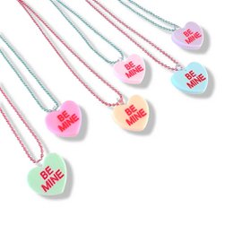 Colorful heart-shaped candy conversation necklaces with "Be Mine" text. Pastel pink and mint green colors. Pendant on a long chain necklace.