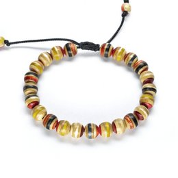 Small red wood bracelet made from recycled skateboards. Features colorful beads in a variety of shapes and sizes. Adjustable cord allows for a customized fit.