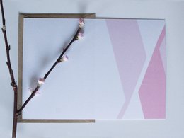 Greeting card with pink and white geometric patterns and a branch with pink blossoms.