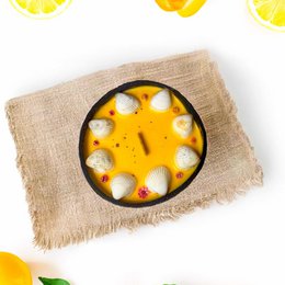  Peach, apricot, and lemon scented candle in a coconut shell container.