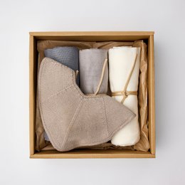  Soft, plush gift box set in shades of silver and gray, featuring a cozy blanket, bib, and other accessories.