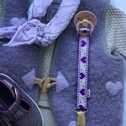 Purple pacifier clip with white polka dots, wooden teether, lavender fabric strap, baby accessory.