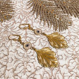 Elegant drop earrings featuring a resin dragonfly charm and wave-shaped mother-of-pearl accents.