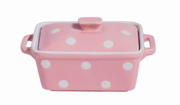 A pink and white polka dot ceramic butter dish with a lid.