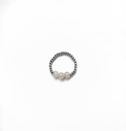 A pink quartz ring with a delicate, feminine design. The ring features a round pink quartz stone set in a silver-toned band, creating a simple yet elegant look. This ring would be a beautiful addition to any wedding or special occasion ensemble.