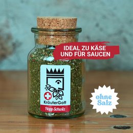 Herb mixture Hopp Schwiiz, a seasoning product in a glass jar with a cork lid. The jar features a graphic design with a crown and Swiss flag. The product is ideal for use in raclette and fondue dishes.