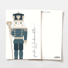 A postcard featuring a hand-drawn illustration of a deer with colorful antlers, surrounded by pine branches and pine cones. The text on the postcard reads "Merry Christmas" in a cursive font.