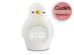 A white and green penguin-shaped sleep trainer with a digital clock display. The product is designed for use in a child's bedroom as a night light and sleep aid.
