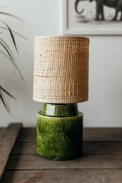 Chic pistachio table lamp with rattan shade and green base. Provides warm, ambient lighting.