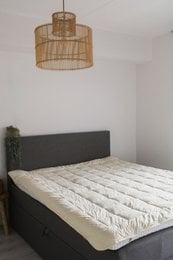 Merino wool mattress topper, available in various sizes, with a natural, soft, and comfortable design.