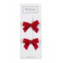 A pair of red bow hair accessories for kids. The bows are made of a soft, velvety material and have a classic ribbon style.