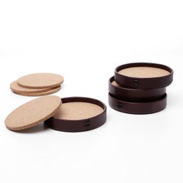 Set of 4 round leather coasters with cork backing, presented in a gift box.