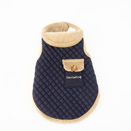 A navy blue and beige quilted dog coat with a high collar and button closure. The coat appears to be made of a soft, insulating material and is designed to keep dogs warm and comfortable.