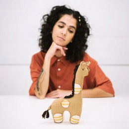 Gaya Giraffe Pillow - Soft, plush giraffe-shaped cushion in neutral tones with textured details.