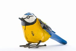  A small, decorative metal statue of a blue tit bird in a bright yellow color. The statue has detailed features like the bird's beak, eyes, and wings.