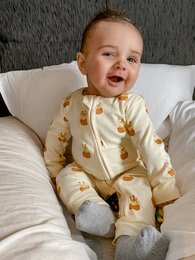Giraffe print zip-up sleepsuit for baby, available in sizes 0-3 months to 12-18 months. Soft, comfortable fabric with a cozy, warm design featuring adorable giraffe prints.