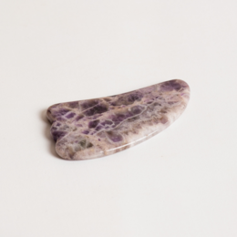 Amethyst gua sha tool with natural purple and white speckled pattern, ideal for facial massage and skin care.