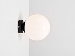 Spherical white glass wall lamp with black metal base, suitable for modern interior design.