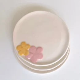 Handmade ceramic dessert plate with yellow and pink flower details, round shape, Spanish pottery, floral design.