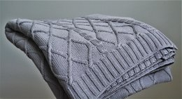 Soft, cozy gray knitted throw with a diamond pattern design, perfect for adding warmth and style to any living space.