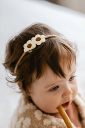  White hairband with small white flowers, suitable for young girls. Soft, comfortable material.