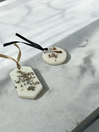 Natural solid air freshener made from soy wax with jasmine aroma, presented on a wooden slice.