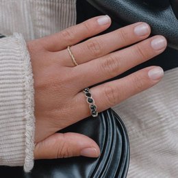 A statement ring with black crystals in a twisted gold or silver band.