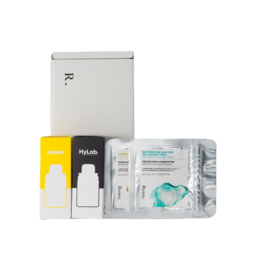 A white box containing various skincare and beauty products, including a yellow bottle, a white bottle, and several small packages.