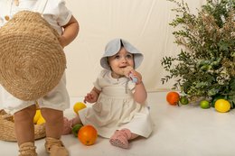 A cozy, soft baby bonnet in a neutral silver color, suitable for infants aged 0-12 months. The bonnet features a warm, plush material and a classic design that complements a variety of baby outfits.