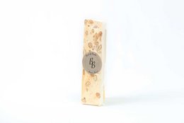  Cream-colored nougat bar with visible almonds and honey, rectangular shape, artisanal confectionery with nuts