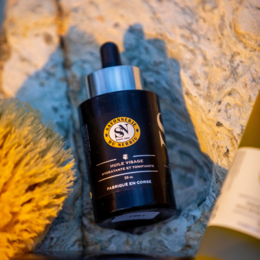 Dry face oil in a black bottle with a dropper. The oil is made from natural ingredients and is designed to hydrate and nourish the skin.