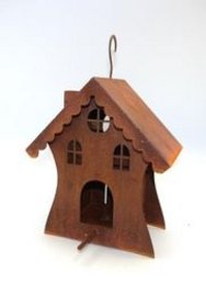 A wooden birdhouse in the shape of a small house with a pointed roof and decorative cutouts. The birdhouse is made of a reddish-brown wood material and has a metal hook for hanging.