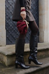  Navy blue suede handbag with kiss lock closure, suitable for everyday use as a cross-body or shoulder bag.