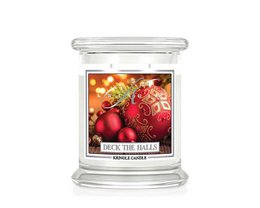  A medium-sized glass jar candle with a festive "Deck the Halls" scent, featuring a blend of cinnamon, clove, and other holiday spices, surrounded by red ornaments and greenery.
