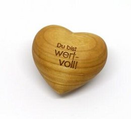 Wooden heart-shaped ornament with the text "Du bist wert voll" (You are valuable) engraved on it, suitable as a gift idea.