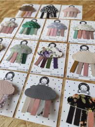 Colorful, whimsical brooch featuring a cloud design with dangling ribbons in various pastel shades.