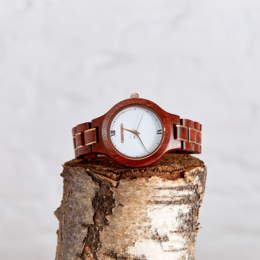 Handmade wood vegan watch with a round, wooden case and a white dial. The watch features a brown leather strap.
