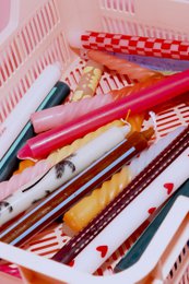 Tall, patterned dinner candle in a variety of vibrant red and orange colors.