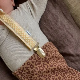 Beige leopard print pacifier clip with gold metal hardware and polka dot fabric strap
