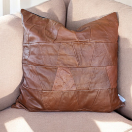 Upcycled genuine leather cushion cover in burgundy, green, and light brown colors. Square shape, textured leather surface.