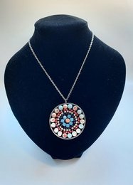 Mandala-style necklace with a round pendant featuring a colorful, intricate design made of various beads in shades of blue, pink, and white.