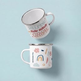 White ceramic mug with "Helping Little Minds Grow" text, educational icons, sun and pencil designs, inspirational teacher gift.