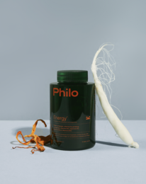 Green supplement container labeled "Philo Energy" with white powder and orange capsules.