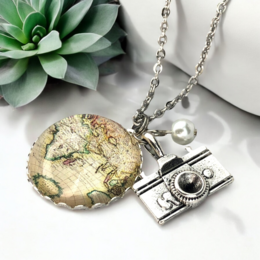 A silver-toned necklace with a globe-shaped pendant and a camera charm, perfect for the wanderlust traveler.