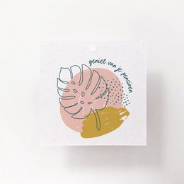 Blush pink gift box with a gift tag featuring a floral design, tied with twine and decorated with a dried flower.