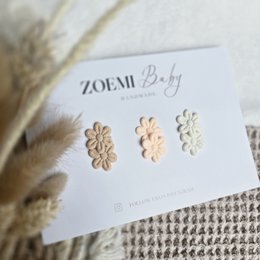 Cheerful mix of hair clips for kids, featuring a heart-shaped clip in a peach color and a floral clip in a neutral tone.