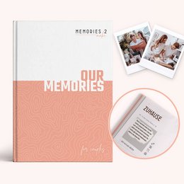 A hardcover book titled "Our Memories" with a pink cover and several small photos attached to the cover. The book appears to be a photo album or scrapbook for couples to preserve their memories together.